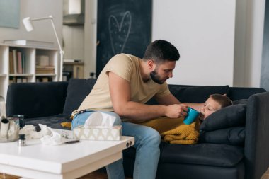 Baba hasta oğluna evde bir fincan çay verir.