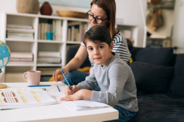 Anne oğlunun ödevlerine yardım eder.