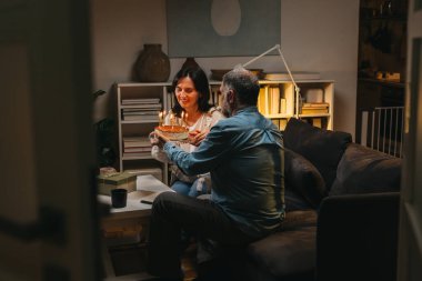 Orta yaşlı çift evde yıldönümünü kutluyor