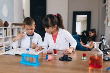 Çocuklar evde kimyasal deneyler yapıyorlar.