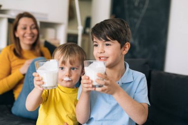 Evde süt içen iki çocuk.