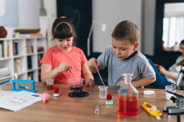 Çocuklar evde kimyasal deneyler yapıyorlar.