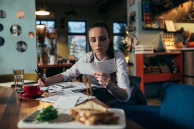 Lokantasında mali işlerle uğraşan bir kadın.
