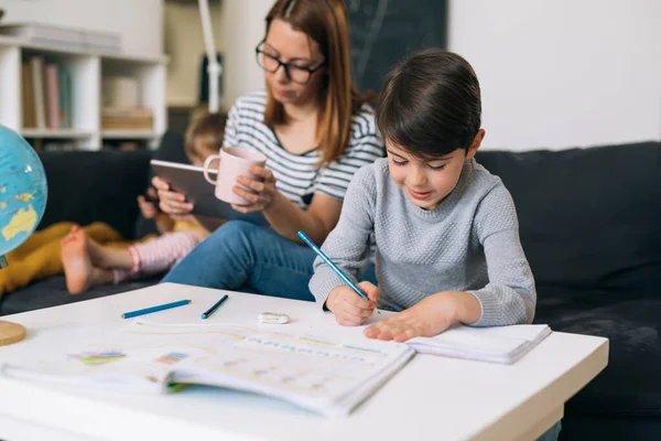 Der Kleine Junge Erledigt Seine Hausaufgaben Hause Mutter Neben Ihm — Stockfoto