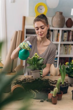 Kadın evde bahçe bitkileri yetiştiriyor.