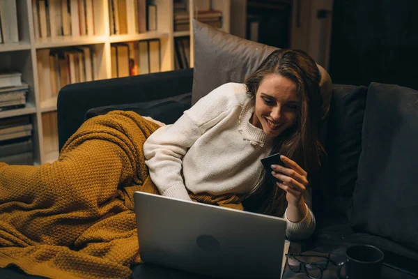 Frau Liegt Auf Sofa Ihrem Wohnzimmer Und Kauft Online Ein — Stockfoto