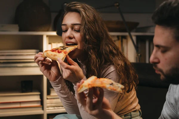 close up of woman eating pizza