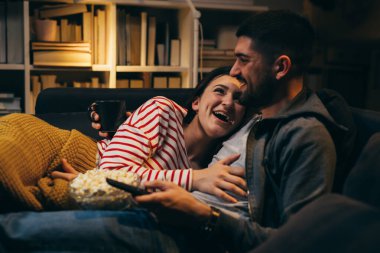 çift evde televizyon izliyor.