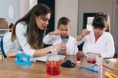 Çocuklar evde kimyasal deneyler yapıyorlar.