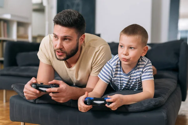 baba ve oğul evde video oyunu oynuyorlar.