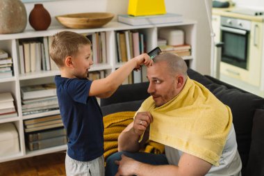 Baba oğul evde oynuyorlar.
