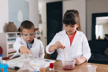 Çocuklar evde kimyasal deneyler yapıyorlar.