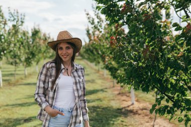 Kadın meyve bahçesinde poz veriyor.