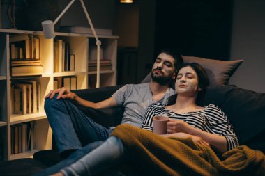 Kozmetik maskeli çift evde dinleniyor.