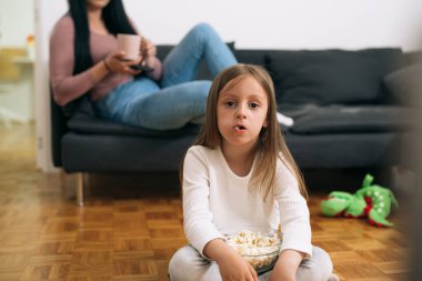 Evde televizyon izleyen genç kızın portresi.