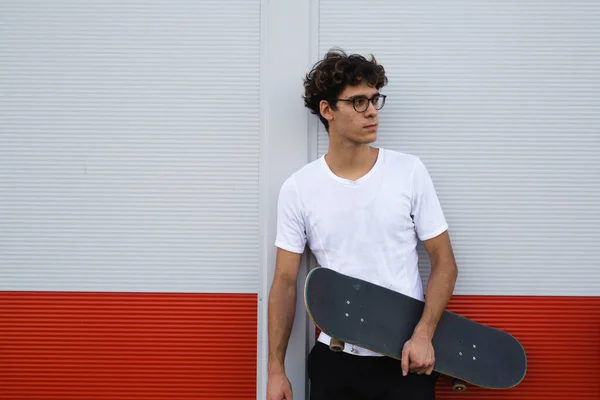 Joven Patinador Posando Aire Libre Apoyado Pared Blanca Roja Mirando —  Fotos de Stock