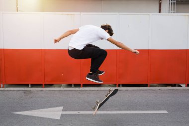 Genç adam kaykayıyla numara yapıyor.