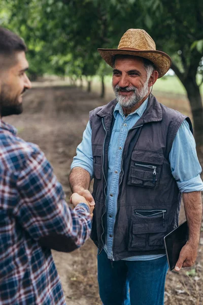 farmers handshake outdoors in filed