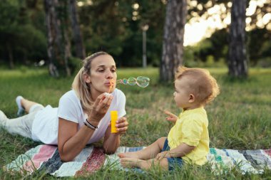 Anne ve oğlu parkta eğleniyorlar.
