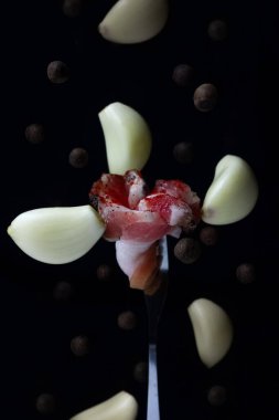 Kırmızı biberli taze pastırma. Havada uçuşan cips ve siyah biber.