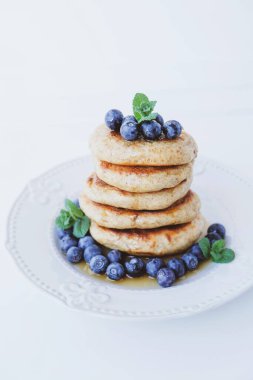 Taze yaban mersini, akçaağaç şurubu ve nane yapraklarıyla servis edilen tam buğday unundan yapılmış ev yapımı küçük krep yığını. Mesaj için yer var. Geleneksel Doğu Avrupa yemeği. Tatlı sağlıklı yemek..