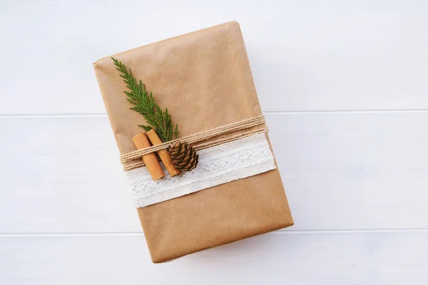 Wrapped gift box with natural decorations such as pine cone, fir branch, cinnamon sticks. Copy space. Zero waste Christmas concept. Plastic free holidays. Sustainable lifestyle.
