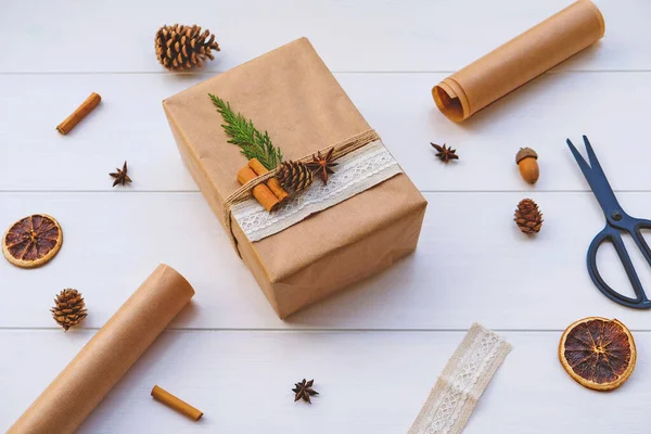 Wrapping gifts with natual decorations such as pine cones, fir branch, cinnamon sticks, dry orange slice. Zero waste Christmas concept. Plastic free holidays. Sustainable lifestyle.