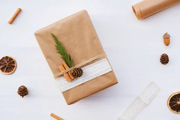 Wrapping gifts with natual decorations such as pine cones, fir branch, cinnamon sticks, dry orange slice. Zero waste Christmas concept. Plastic free holidays. Sustainable lifestyle.