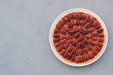Lezzetli taze ev yapımı fındıklı turta gri beton arka planda.