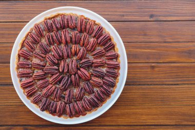 Ahşap kırsal arka planda taze ev yapımı nefis cevizli turta. Üst manzara, düz yatış. Şükran Günü ve Noel için popüler bayram yemeği.
