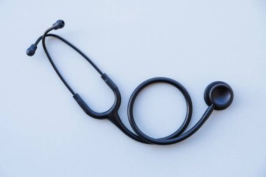 Gri arka planda siyah tıbbi steteskop. İlaç ve sağlık hizmetleri. Mesaj için yer var. Düz-yatay, üst görünüm.