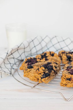 Beyaz ahşap arka planda böğürtlenli ev yapımı yulaflı çörekler. Vejetaryen tatlı pişmiş yemek. Glütensiz hamur işi.