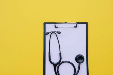 Siyah steteskop ve sarı arka planda boş tıbbi form..