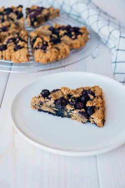 Beyaz ahşap zemin üzerinde taze pişmiş yulaflı çörekler. Doğal malzemeli tatlı yiyecekler. Vejetaryen glütensiz pasta..