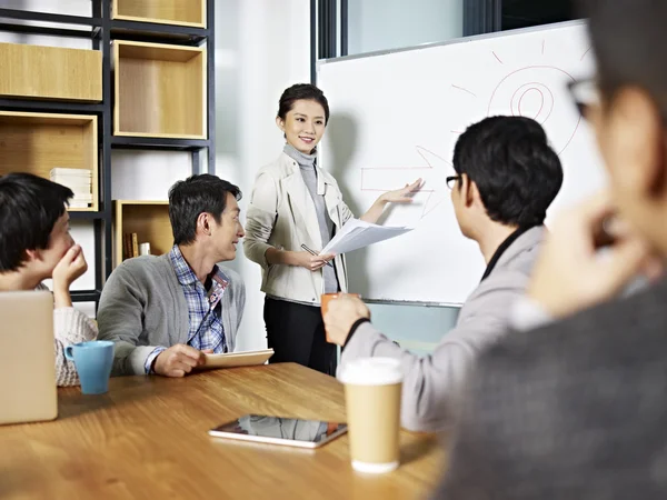 Unga asiatiska affärskvinna att underlätta en diskussion — Stockfoto