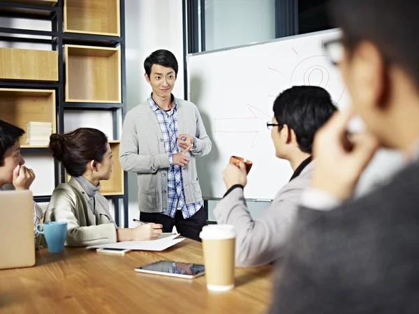 Unga asiatiska affärsman att underlätta en diskussion — Stockfoto