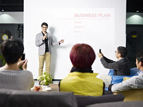 Jonge Aziatische man die presenteert businessplan — Stockfoto
