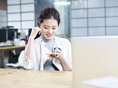 kadın cep telefonu kullanarak Asya ofis