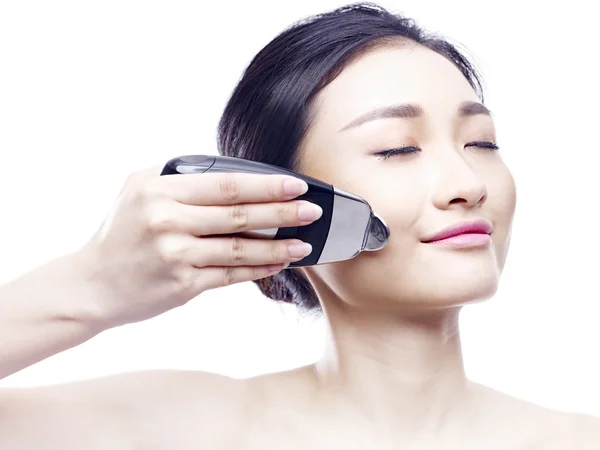 Junge asiatische Frau mit einem Gesicht-Wellness-Gerät — Stockfoto
