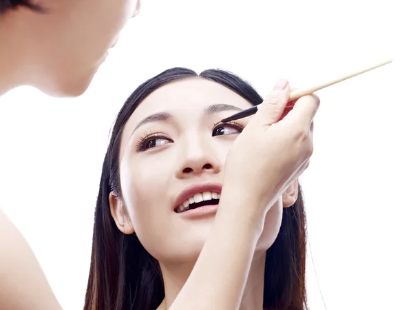 Smink művész dolgozik egy női ázsiai modell — Stock Fotó