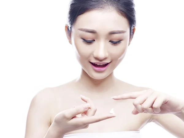 Young asian woman applying cream — Stock Photo, Image