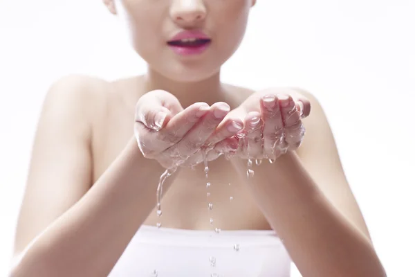 Молодая женщина умывается водой — стоковое фото