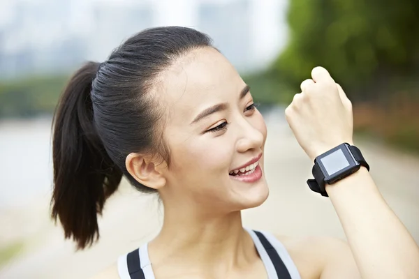 Young asian runner with wearable fitness device — Stock Photo, Image