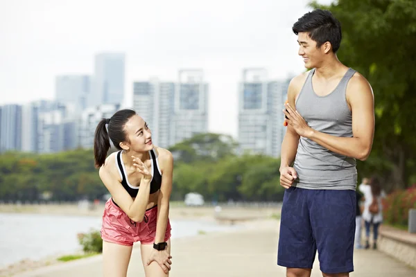 Asian man and woman runner saying hello to each other — Stock Photo, Image