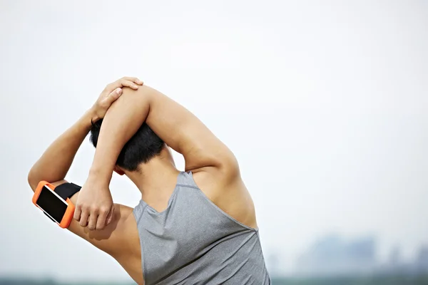 Young asian jogger stretching arms before running — Stock Photo, Image