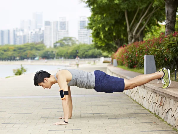 Joven asiático hombre haciendo flexiones en parque —  Fotos de Stock