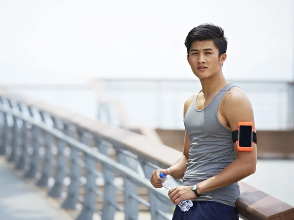 Jovem asiático homem tendo um intervalo durante ao ar livre exercício — Fotografia de Stock