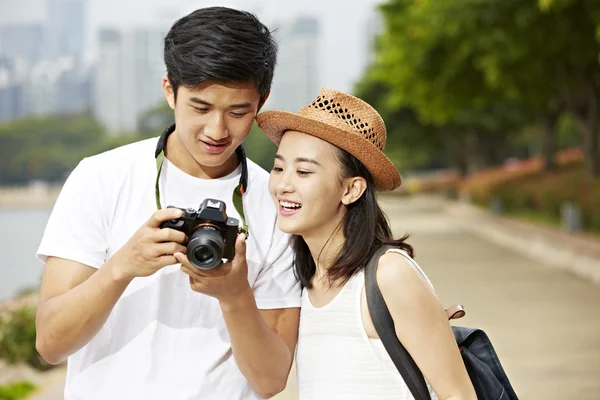 Young asian tourists checking pictures in camera — Stock Photo, Image