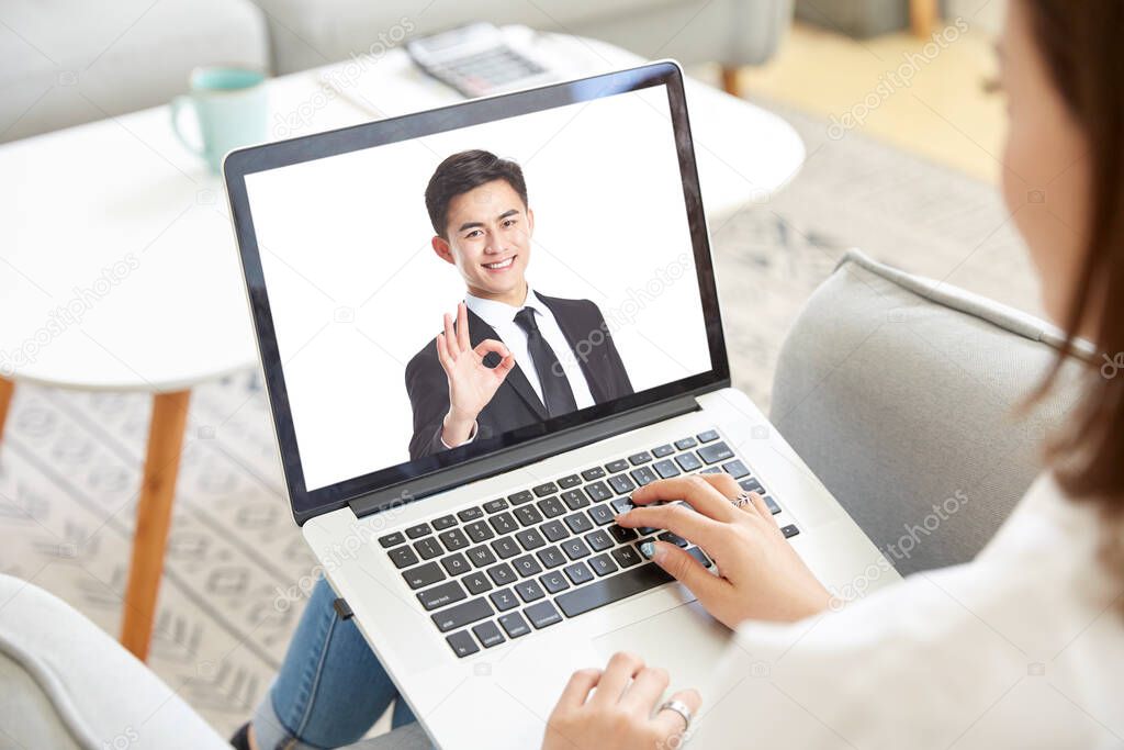 young asian business woman working from home meeting with colleague online via video chat using laptop computer