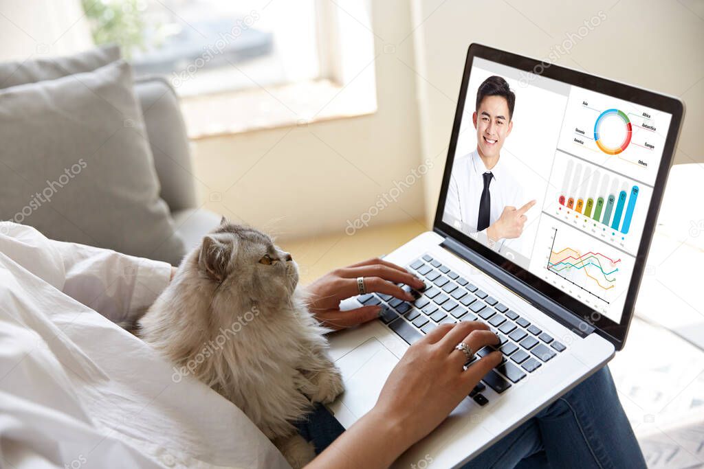 young asian corporate executive participating an online business presentation via video conference using laptop computer